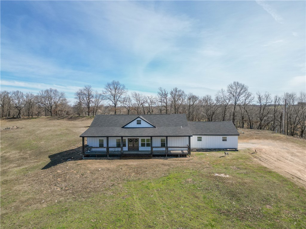 Nestled on 10 acres, across the street from a Nature Reserve, this stunning Craftsman-style home blends classic charm with modern comfort. With expansive views of rolling hills, it offers a peaceful retreat just 15 minutes from NW Arkansas Regional Airport. The open floor plan highlights beautiful craftsmanship, while the large front porch provides the perfect space to enjoy the views. Inside, the spacious living area is filled with natural light, and the kitchen boasts quality appliances and ample butcher block counter space. The primary suite is a sanctuary, featuring a walk-in shower, freestanding tub, and a generous walk-in closet with built-in storage. Two large secondary bedrooms share a Jack and Jill bathroom, each with walk-in closets. A dedicated quiet office offers an ideal work-from-home space. The property is secured by an electric gate. enjoy outdoor activities and breathtaking views! Inquire about preferred lender for a closing cost credit.