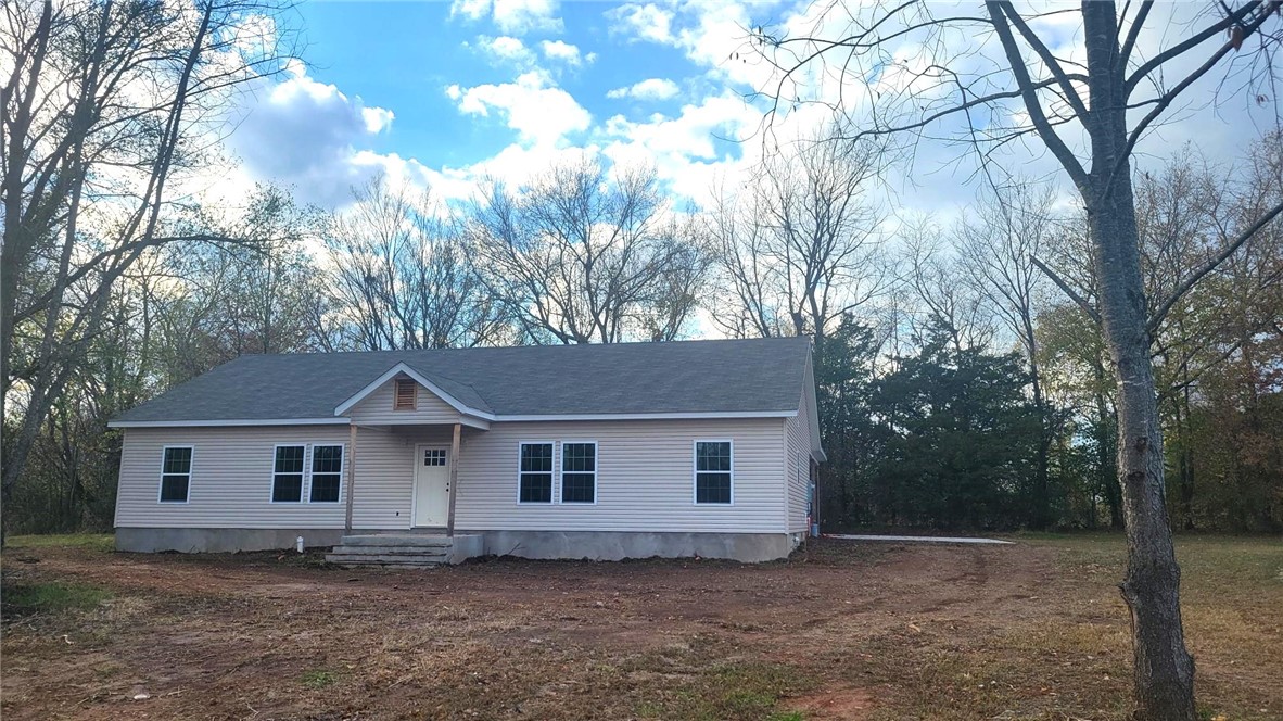 New Cottage Style home sitting on a wooded lot. These homes have upgraded finishes! Tiled walk in shower in master, extra closet built ins, NO carpet, large island and quartz counters. We can show you a finished home at 224 Ft Smith (same plan). Get so much more for the money. House will be painted dark green soon! Gravette paved walk/bike path is adjoining this development.
