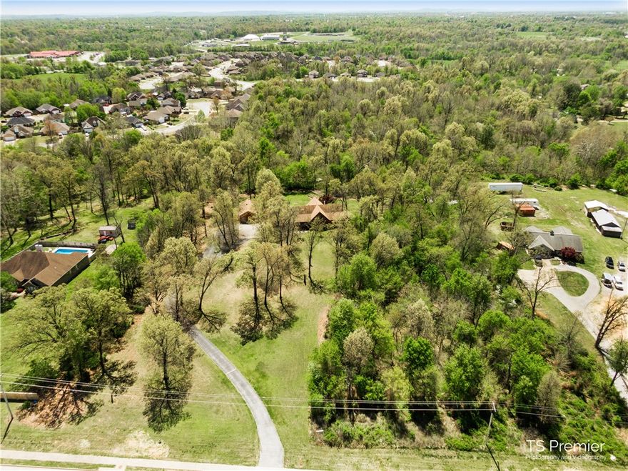 This beautiful custom home sits on 16 acres and has 3,500 square feet of living space, 3 spacious bedrooms on the main level and 2 spacious rooms upstairs that could be bedrooms plus bonus rooms, office, or play room. 2 hvac systems and 2 hot water heaters. Living area is very spacious with lots of natural light, high ceilings and real hard wood floors. The kitchen has a gas stove fit for a chef. Relax on the lovely deck over looking the beautiful park like setting. Use the detached garage for hobbies or to park your boat. Property is close to Springdale Lake and JB Hunt Elementary. This is a prime location in the middle of Northwest Arkansas with great development potential and only 1 minute from I49. Great location for a family business. New Roof 2022!