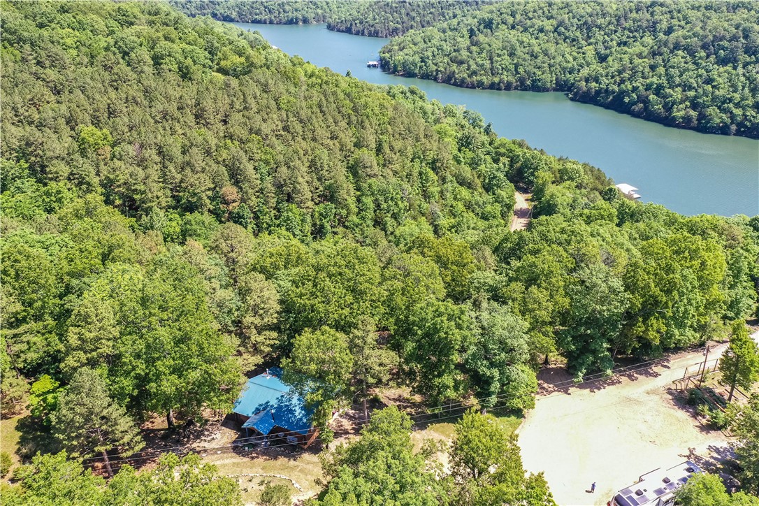 Private boat dock with a 12x26 slip on Beaver Lake. Charming cabin in the woods with a Beaver Lake view. Custom details through out this log cabin home. Metal roof and woodstove are 3 years old. Land has a mild slope so you can garden. Custom kitchen with unique pantry. Open living room with access to deck. 2 bedrooms and 1 bathroom upstairs. Full basement with a den area, bathroom, and large storage area not included in square footage. Extra large carport that will fit large boats or a RV, bring your toys. Home can be used as a nightly rental.