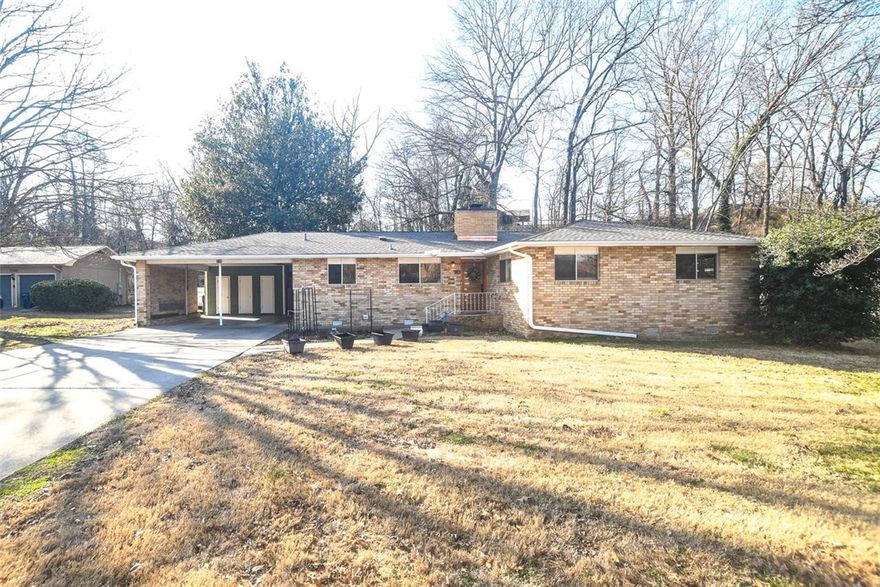 Charming all-brick ranch with mid-century modern appeal, built in 1965 and thoughtfully updated. Original hardwood floors and bathroom tiles. The updated kitchen includes newer appliances including a wall oven and gas cooktop. Major improvements include a brand-new roof, new HVAC, water heater, and updated plumbing beneath the home. Situated on a spacious 0.61-acre lot, this property is conveniently located near downtown Siloam Springs, parks, walking trails, and John Brown University. Entry from the carport leads to a versatile flex room ideal for a home office, with the laundry room and an additional bathroom located at this end of the home. An attached all-brick carport/storage area (346 sq ft) includes water and electric access, offering potential for future conversion to additional living space, guest quarters, or an in-law suite (buyer to verify). Enjoy the heated and cooled sunroom overlooking the backyard. Beautifully maintained and ideally located.