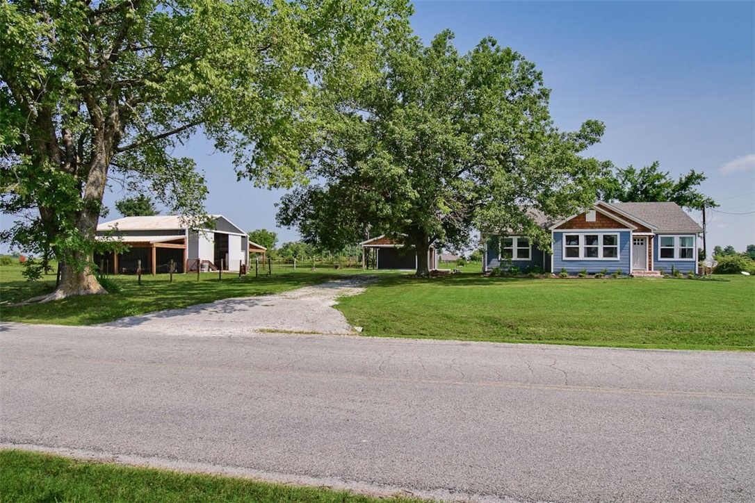 Come see this adorable mini farm! Beautiful country setting on 5 acres and still only 5 minutes to Wal-Mart! This charming farmhouse has original restored wood floors, tons of new windows that add great lighting. Board and batten wall paneling that make everything feel cozy along with the electric fireplace in the living room. Open kitchen has a farm sink, gas range, and vented hood. Huge laundry/mud room also has room for a freezer. Dining room has a butler’s pantry with mini fridge. The Remodeled bathroom has white sub-way tile shower surround, pretty new vanity, and fixtures. You will enjoy countless moments on the outdoor covered screened in porch w/ceiling fans. There is also an outdoor pergola grilling area and fire pit. The 23x36 barn/shop has concrete floors, electric & horse stalls. 24x30 carport for two vehicles & on the back side it has a garage door w/extra storage area. Property also has an 8x16 storage building & wireless dog fence in front & back yard and will come with 2 collars.