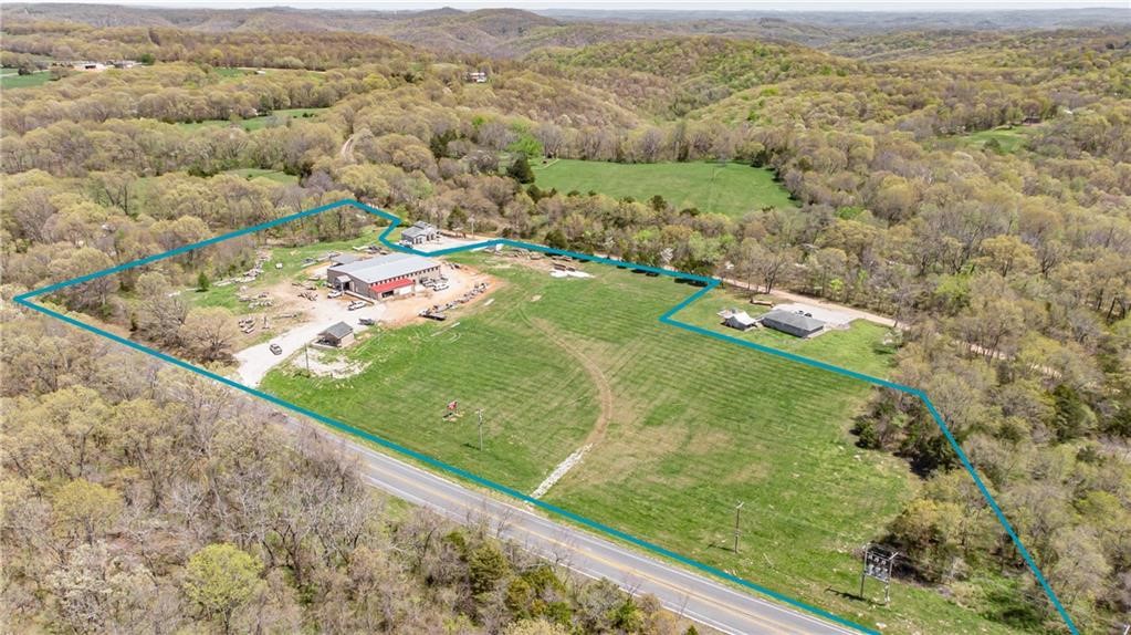 Don't miss this high-visibility property on Hwy 62! With around 8 acres of flat, cleared land, this property offers a 9,000 sqft shop, updated and ready for your next venture, plus a cabinet-making shop. The property also includes a house and outbuilding, adding even more potential for future use. Act now to seize this unique opportunity—property only, business and equipment are not included. The current owner will lease back the property for 6 months.