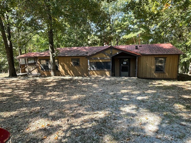 Situated on 1.78(+/-) wooded acres, this home is on a permanent brick foundation located near Hobbs State Park and close to Beaver Lake. Property has its own well, covered front porch, side porch and covered deck. Several outbuildings for storage. This is a total renovation project for the right buyer! Sold AS-IS.