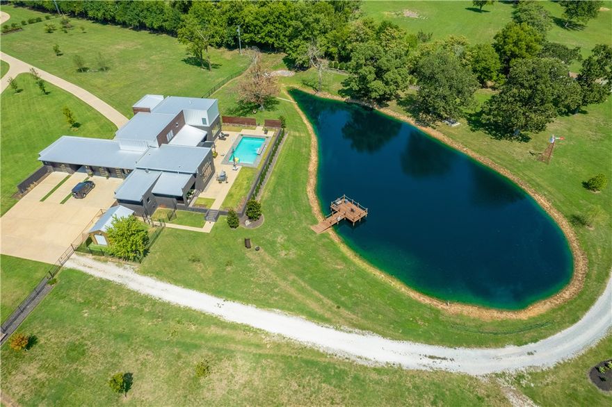 Stunning Modern Estate property. Approx. 9.43 fenced in acres with gated smart entrance. Builder says this house could not be built for this price today. Two minutes from 112/ 612 to interstate, 13 min from Tyson head quarters, and 7 minutes to hospital, WM, Starbucks, or Sam's. Raised, heated saltwater pool overlooks three quarter acre stocked pond with dock. Storage barn by gated entrance. Main house was completed in Aug. 2017 has chef's kitchen with Brazilian quartzite and large walk in pantry. Two fireplaces and a staircase with inlaid walnut. Two ground floor masters. Multiple entertaining areas and soaring 14 ft. ceilings. Natural light floods in with the abundance of large windows. This home is a must see.