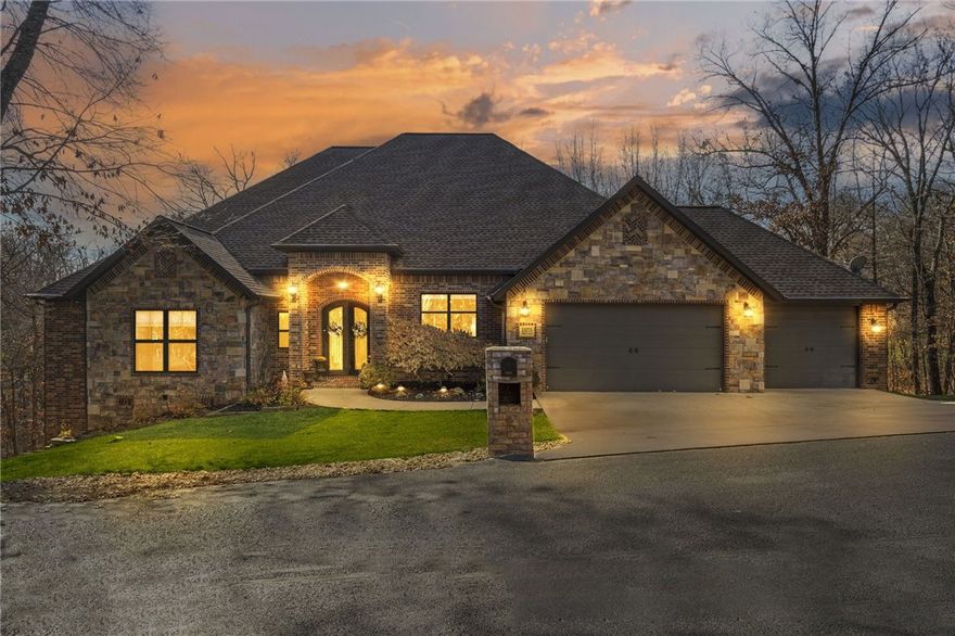 Welcome to this beautiful custom home on 1 acre oasis. Located only minutes from the 49 Bypass, one can quickly access all the conveniences of both Bentonville and Bella Vista as well as easily navigating to any of the area headquarters for work. When entering the foyer thru gorgeous iron doors, you are welcomed by a thru-view of soaring ceilings, spacious living and your spectacular wooded backdrop. The main floor boasts an open concept offering a large living room, a well-appointed kitchen with either a breakfast area or sitting area with fireplace and 3 bedrooms. When venturing downstairs, you enter another over-sized living area with wet bar from which you can explore the adjacent gameroom, exercise room, bonus room and guest suite. In addition to these spaces, there is also an oversized storage room. To enjoy your scenic views, there is a balcony off the main living area as well as 2 decks accessible from the downstairs living room, one of which offers an hot tub. Come see this gem for yourself!