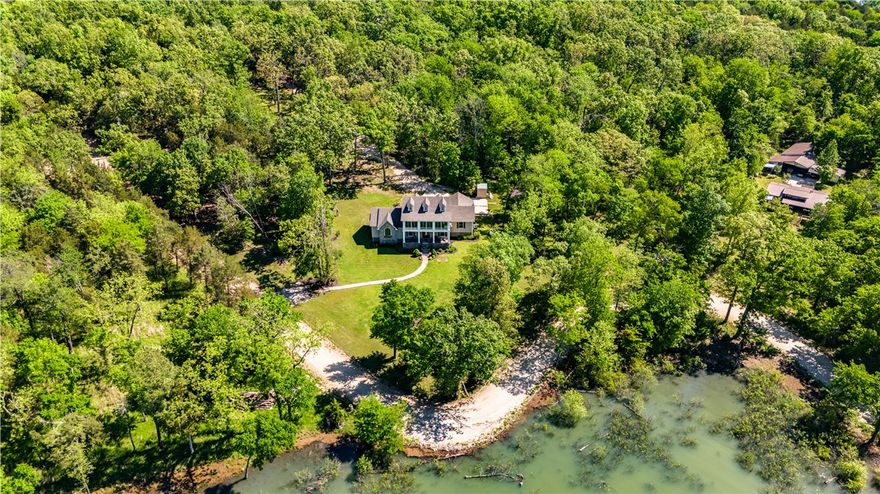 Tucked along the sparkling shores of Beaver Lake, this stately colonial-style retreat sits on 4.09 serene acres just 30 minutes from Downtown Rogers. With 271 feet of core frontage, a private walking path leads to the beach where lake views stretch endlessly and a boat slip with lift and swim deck awaits. The spacious 3,287 sq ft home invites connection and comfort with 4 bedrooms, 2 full and 2 half baths, a bonus room, and a sunroom designed to soak in every season. Recent updates include new roofs, luxury vinyl flooring, fresh paint, a whole house surge protector, and a new dishwasher—so you can relax from day one. Beyond the home, a 30x60 heated workshop with its own septic, bath, W/D, kitchenette, and storm shelter offers endless potential: guest quarters, RV haven, studio, or business base. Plus, an underground pet fence and level lot mean ease for everyday living. Whether you're chasing lake life dreams or seeking a forever getaway—this is where it begins.