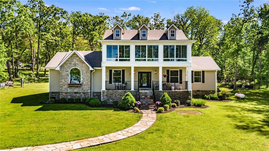 Tucked along the sparkling shores of Beaver Lake, this stately colonial-style retreat sits on 4.09 serene acres just 30 minutes from Downtown Rogers. With 271 feet of core frontage, a private walking path leads to the beach where lake views stretch endlessly and a boat slip with lift and swim deck awaits. The spacious 3,287 sq ft home invites connection and comfort with 4 bedrooms, 2 full and 2 half baths, a bonus room, and a sunroom designed to soak in every season. Recent updates include new roofs, luxury vinyl flooring, fresh paint, a whole house surge protector, and a new dishwasher—so you can relax from day one. Beyond the home, a 30x60 heated workshop with its own septic, bath, W/D, kitchenette, and storm shelter offers endless potential: guest quarters, RV haven, studio, or business base. Plus, an underground pet fence and level lot mean ease for everyday living. Whether you're chasing lake life dreams or seeking a forever getaway—this is where it begins.