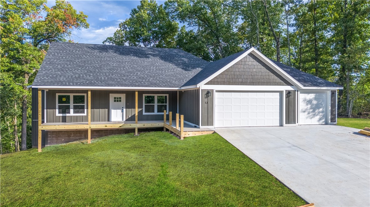 This breathtaking farmhouse style with open floor plan is a must see, sitting on a lot with picturesque views yet located so close to everything. From the eye-catching front porch, you enter & are greeted with towering ceilings, & a wealth of natural lighting in a large main living area. There are many high end features, beginning with the beautiful light wood LVP & cathedral height stone fireplace. As you continue through the home, you will find the spacious kitchen with tons of cabinet space, stunning oversized island open to eating & main living. From here you can wander to the back patio, overlooking a gently sloped beautiful back yard with trees. The spacious owners retreat features huge closet and a spa-like walk-in shower. Off the kitchen there is a half bath and an oversized, dreamy, laundry, room with cabinetry and access to the owner's closet. Nearby is the handy half bath for guests or quick stop from the outdoors. All this so close to Bentonville and Bella Vista shopping & Trails as well as Walmart HQ