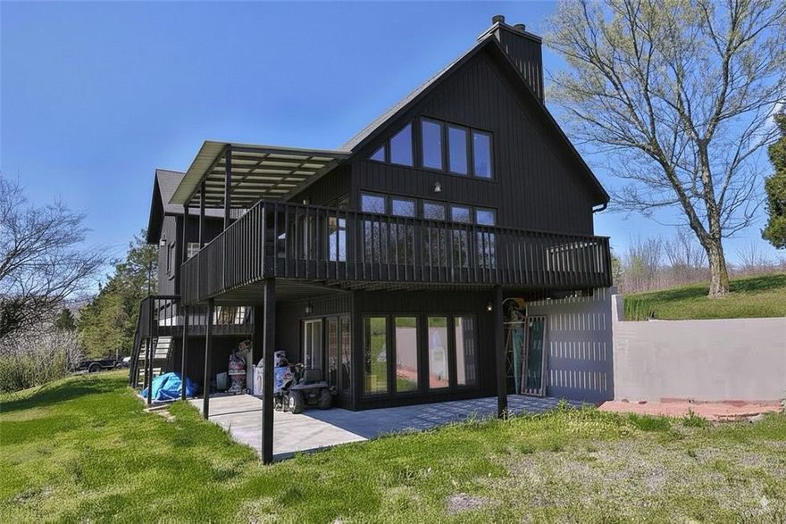 Newly remodeled custom cedar home on 2.5 acres in Hickory Creek—just 2 mins from Beaver Lake marina! Built with durable Steel I-beam construction, this home offers stunning views from every floor, floor-to-ceiling picture windows, and a wrap-around deck/patio. The open-concept main level features a 22-ft stacked quartz wood-burning fireplace connecting the living, kitchen, and dining areas. The master suite includes a walk-in closet and a luxurious marble walk-in shower with rain head. A second bedroom and bath feature custom tile and jetted tub. Upstairs, a rod-iron/wood staircase leads to a loft, third bedroom, and bath with a body jet shower. Walkout basement includes a stacked quartz fireplace, wet bar w/ sink, cooler & dishwasher, half bath, and storm shelter. Insulated 2-car garage has a built-in workshop. Outside: gazebo, fenced garden, fruit trees, and more. Too many high-end finishes to list—plus, many items convey. New exterior paint will be finished soon. Seller financing available!