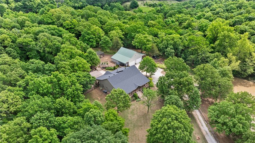 This isn't just a house, this property is a lifestyle. Escape to your own private retreat. This stunning home was completely remodeled starting in 2017. One hundred year old refurbished wood floors and barn beams were brought in during the remodel. The home is nestled privately among the trees and surrounded by nature but still is open to a beautiful private view. The property features a large, well-stocked pond - ideal for an afternoon of fishing or sitting on the overlook by the fire. The spacious shop is equipped with a wood burning stove, lots of cabinets and wired for TV.  Property offers a beautiful fenced backyard with custom built garden house along with raised beds, a large layered deck that is great for entertaining with lots of options for seating arrangements, a pergola covered cook area, and lots of wildlife to watch. Professionally installed landscaping is complete with irrigation. House is equipped with a backup 400 gallon storage tanks approved for drinking water along with a whole house generator.