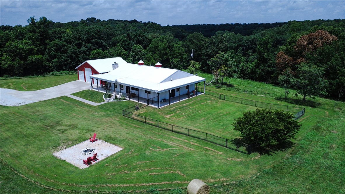 This beautiful 36.89 acre property includes a 2,481 SF farmhouse with large covered patio, 1,480 SF detached garage and a 3,430 SF pole shed for storage. There is a 1/2 acre stocked pond, and a gun range near the pond. Perfect located for a private retreat or additional single family residences. The property is very well maintained with panoramic views and wooded surroundings. The house was renovated in 2022 and has many high end finishes and a storm shelter. A must see property!