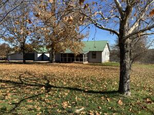 Looking for that quality home with a view and land to enjoy in an excellent location? Don't miss this 3br/2ba, 1700 ft2 m/l home with bonus 1br/1ba living space in detached 2 car garage. Property consists of 15 m/l mostly open acres, fenced and cross fenced, raised bed garden area, shade trees. Find plenty of flexible space in the additional 2 car outbuilding with lean-to, storage buildings, and large barn set up for animals. Solid built home boasts an open floor plan w/vaulted ceilings, kitchen pantry, wood stove for additional heat source. Low maintenance exterior with new siding and new HVAC and a screened porch to take in the surroundings. Conveniently located to all NWA offers. Paved road to the property while maintaining a country feel. So many features and possibilities to make it