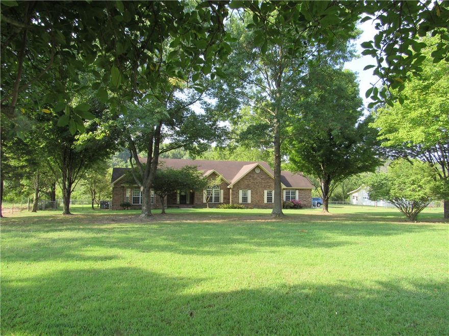 This is a rare and unique 10 acre property in one of NW Arkansas' most desired areas, just a short commute to Bentonville, Fayetteville or Springdale.  Only a few minutes drive from Highways 112, 412, 612 and I-49.  You will enjoy the peaceful surroundings, including a pond, a spring fed creek that flows year round, and the rear wooded area of wildlife habitat you can observe from the breakfast area or living room, or from the deck which overlooks the pond and pasture.  The shop building can house a travel trailer & is also set up as a workshop.  The house and shop building have new architectural shingles.  The kitchen has many cabinets, a built-in desk, pantry and center isle. Walk in closets and hallway closets provide lots of storage.  Side entry garage & large utility room.