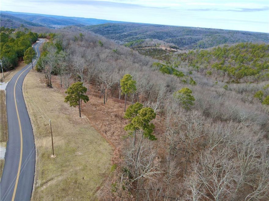 Discover the perfect blend of natural beauty and convenience on this 11.33+/- acre tract with paved road frontage in the heart of the Ozarks. This property offers a cleared build site positioned to capture peaceful mountain valley views, giving you a great location for your cabin, home, or getaway retreat. Electric is already on site, helping streamline your building plans and reducing upfront costs. The land is graced with mature pine and oak timber that provides privacy, shade, and a classic Arkansas woodland setting, while unique rock formations add character and a rugged, scenic touch rarely found on smaller parcels.
Located just 11 minutes from historic downtown Eureka Springs, you can enjoy dining, shopping, and local culture within a short drive while still feeling tucked away in nature. Outdoor enthusiasts will love being only 12 minutes to Table Rock Lake and 12 minutes to the Kings River. Whether you’re looking to build now or invest for the future, this property combines location, usability, and charm.