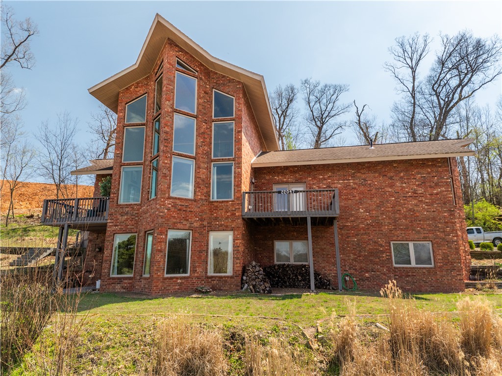 Nestled atop the scenic Dawn Hill, this grand 3-level brick home offers breathtaking views with expansive windows that bring the outdoors in. With 4,200 sq ft of living space, this beautifully crafted home showcases exquisite woodwork and a perfect blend of elegance and comfort. The kitchen is a chefās dream, featuring granite, glazed cabinetry, and a gas cooktop. 3 bedrooms and 2.5 bathrooms, this home also offers multiple outdoor patios ideal for enjoying the panoramic views. Inside, youāll be greeted by a stunning rod iron staircase and fireplaces on every level that add to the warmth and charm of this home. The lower level is designed for entertainment, complete with a pool table and wet bar. Heated floors throughout ensure year-round comfort. Constructed with 2x6 walls and insulation. New paint in bedrooms, new carpet upstairs/downstairs, new dishwasher and new upstairs HVAC. A rare opportunity to own a home that offers both sophisticated design and ultimate functionality, with an unparalleled location.