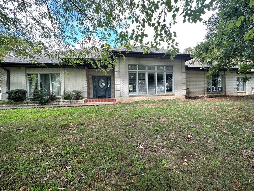 Discover the tranquil living with this magnificent 3-bedroom 3-bath home that sits gracefully on a sprawling 3.41 acre lot offering an additional 18 acres of pristine land for your personal paradise nestled just minutes from the vibrant heart of downtown Springdale. This home provides the perfect balance of natural serenity and urban convenience. Home is being sold as-is