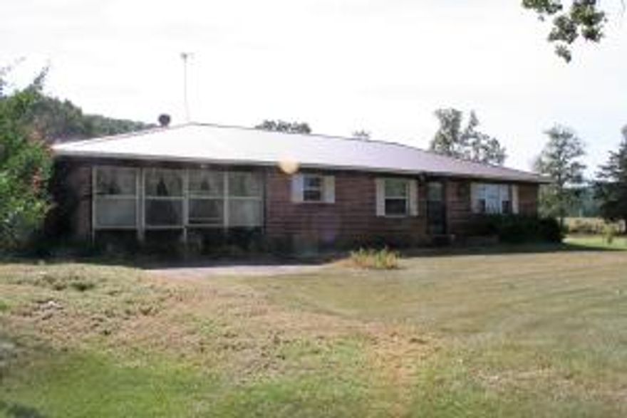 5 acres with a 3 bedroom brick home, barn, pond, fenced and cross fenced ready for your animals. Home had new windows and added insulation about 5 years ago. There is an enclosed garage that now serves as a man cave with laundry room and 1/2 bath. The home is on city water but also has a well. Metal Roof and 2 car carport.