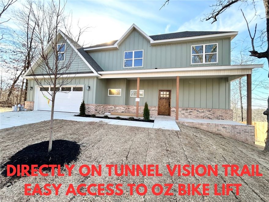 New construction with bonus room on a large wooded lot directly on Tunnel Vision Trail and close to Lake Windsor boat launch! Provides easy access to the OZ Bike Lift and Downtown Bentonville. You will be hard pressed to find a better location. Step inside to discover a beautiful fireplace, custom cabinets, gas range, and elegant 3 cm quartz countertops. This thoughtfully designed home features 3 spacious bedrooms plus a versatile bonus room, providing ample space for entertainment. The primary bedroom is conveniently located on the main level. Bentonville schools! As an added bonus, this home includes $3,500 in buyer's closing costs when using the builder’s preferred lender!
