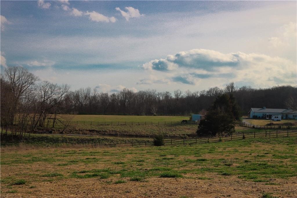 Fifteen acres in northeast Fayetteville! Through the gated entry and down a paved 1/4 mile driveway, you will find fifteen beautiful acres just waiting to become the estate of your dreams. This acreage offers improved, fenced pastures, shop and horse barn, large pond, some mature shade trees and very private estate sites. Truly a one of a kind offering in an area of prestigious homes. Can be used as an estate or divided into as small as three acre tracts.