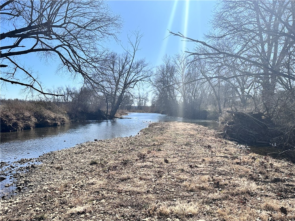 Build your dream home on this gorgeous lot in an upscale planned family oriented large lot natural subdivision. 3.86 acres of rolling wooded land is just waiting for your dream to become reality with plenty of space to play and lots of nature in your front and back yard. The Little Osage Creek is just across the way and you get use of the 9 acres of common area on The Little Osage Creek to fish, swim, kayak, canoe, wade or just enjoy. This exceptional lot is just waiting for you and your family to build your forever home.
Lowell's Exit 78 on I49 is just 15 minutes away, making it easy to access the amenities of nearby cities. XNA is about 5 minutes away. The property is fully equipped with essential utilities, including water, gas, and electric. The only thing missing is a septic system, which will need to be installed by the new owner.