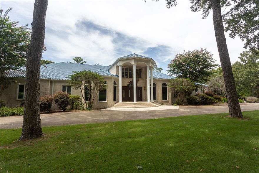 This may be your once-in-a-lifetime opportunity to own an iconic piece of Russellville history. Resting on the banks of Lake Dardanelle, this grand home is the epitome of luxury, exclusivity, and a life of peace. This majestic estate spans over 7 acres of park-like, manicured grounds, offering a tranquil retreat that is just moments from town. The grandeur of this stately home is immediately apparent upon entry, with its expansive 15,000 square feet of living space that includes a wonderful indoor pool and spa for year-round enjoyment. Boaters will delight in the private, 2-slip boat dock with lift, offering direct access to the beautiful waters of Lake Dardanelle. The property's own movie theater ensures unforgettable entertainment experiences to enjoy in the comfort of your own home.
The carriage house includes over 3,000 sf of space, including an enclosed shop with bathroom which is climate controlled for your comfort. The elevator, built-in sub-zero refrigerator, wine cellar and sauna are just a few amenities!