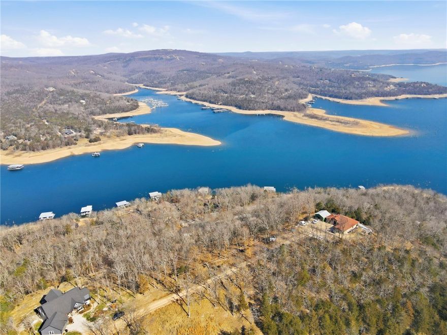 Perched up on the ridge in the Cedar Acres neighborhood of Lost Bridge Village, this .89 acre homesite offers privacy, tranquility, and the potential for beautiful Beaver Lake views with some selective clearing.  Currently mostly wooded and located near the end of the road, the lot provides a peaceful setting to design and build your custom lake retreat.  Septic and well required.  Owners enjoy Lost Bridge amenities including the community pool, pickleball court, rec center, air strip, and more!  If you have been dreaming of building near the water amidst natural surroundings, with space, serenity, and community perks, this is your opportunity to bring that vision to life!