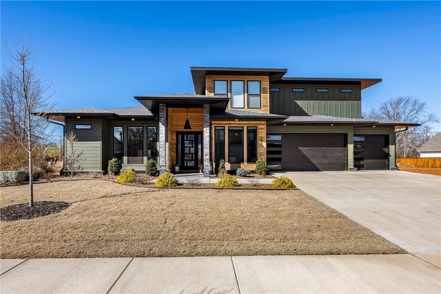 Welcome to your dream home, a contemporary residence located in a serene cul-de-sac in the heart of Bentonville. With 5 spacious bedrooms & 5.5 bathrooms, the open-floor plan features a gourmet kitchen, with granite countertops, gas range, double ovens, large island with vegetable sink, drawer microwave, & pantry for extra storage. The living, dining & kitchen area have hardwood floors, recessed lighting, built-in shelves, motorized shades and a linear-gas fireplace. For casual gatherings, the bonus room is located next to the kitchen with wet bar and beverage frig. The primary suite offers a deep tub, walk-in shower with dual shower heads, double sinks with adjoining walk-in closet connecting to the laundry room. Upstairs there are 3 secondary bedrooms, each with a private bath. The exterior features a privacy fenced backyard, covered porch and patio area with a bike wash station for outdoor enthusiasts. This location offers proximity to Coler Mountain Bike Preserve, Bentonville Square, shopping, and fine dining.