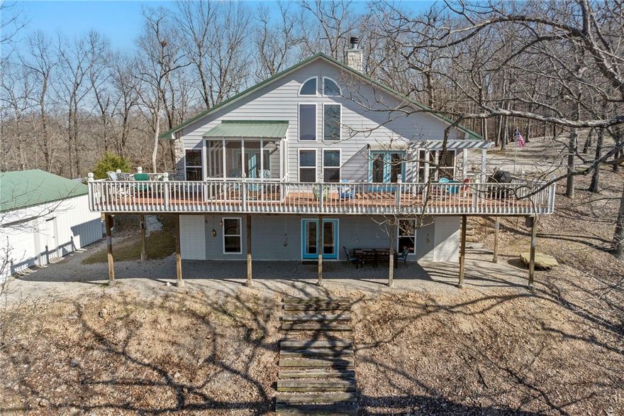 Lakefront property priced to sell below appraisal value. Private cove & boat dock on 14+ acres on Beaver Lake. Welcome to lake life at its best, offering equal parts fun & relaxation + convenience & privacy; a combo that makes this a rare find! Enjoy stunning views of Point 5, combined with the ease & convenience of having your own 2-slip boat dock. Built in 2004, the 3,240 sq. ft., 3-bed, 3-bath home offers spacious, open-concept living w/ a finished basement, perfect for entertaining or guests accommodations, featuring 10” reinforced concrete walls & 10’ ceilings. An expansive deck provides the perfect setting for gorgeous sunrises & sunsets over the lake, while the front patio provides a peaceful spot to simply enjoy being surrounded by nature. Property includes 2 metal buildings (30x40 & 24x33 - one w/drive thru garage doors) for boats, RVs, or workshops + a 10x20 greenhouse for year-round gardening. Durable hardy board siding ensures longevity. Attic area prep’d & ready to be converted into a loft if desired.