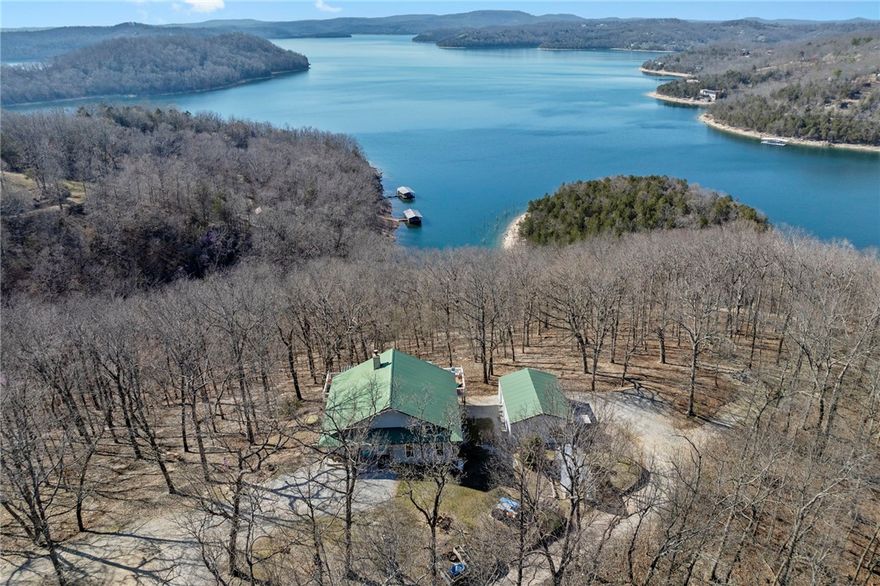 Lakefront property w/ private cove & boat dock on 14+ acres on Beaver Lake. Welcome to lake life at its best, offering equal parts fun & relaxation + convenience & privacy; a combo that makes this one a rare find! Enjoy stunning views of Point 5, combined with the ease & convenience of having your own 2-slip boat dock. Built in 2004, the 3,240 sq. ft., 3-bed, 3-bath home offers spacious, open-concept living w/ a finished basement, perfect for entertaining or guests accommodations, featuring 10” reinforced concrete walls & 10’ ceilings. An expansive deck provides the perfect setting for gorgeous sunrises & sunsets over the lake, while the front patio provides a peaceful spot to simply enjoy being surrounded by nature. Property includes 2 metal buildings (30x40 and 24x33 - one w/drive thru garage doors) for boats, RVs, or workshops + a 10x20 greenhouse for year-round gardening. Durable hardy board siding ensures longevity. Attic area prep’d & ready to be converted into a loft if desired.