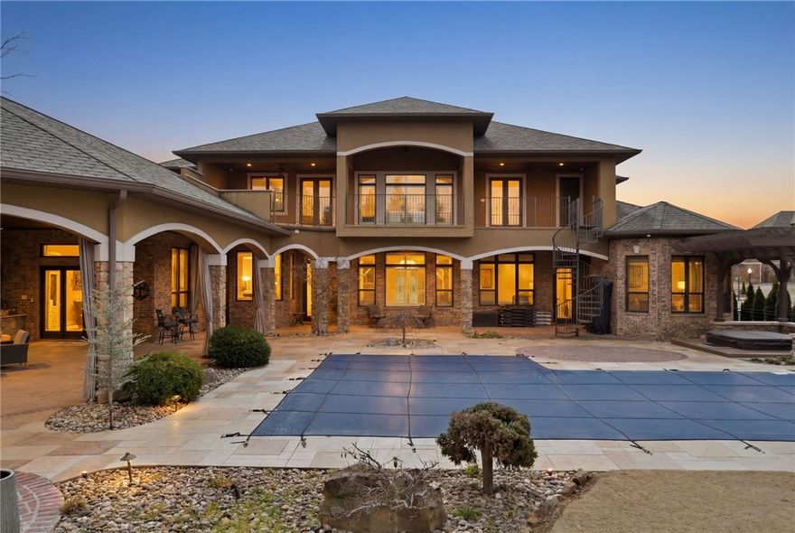 Located in the prestigious gated community of St. Valery Downs, this exceptional custom estate offers privacy, security, and unbeatable convenience—centrally positioned in the heart of Northwest Arkansas. This two-story residence blends luxury and functionality with high-end upgrades and built-ins throughout. Featuring new roof and windows (2025) and situated on 1.1 acres, the home includes a FEMA-compliant tornado safe room on the main level. Enjoy an expansive open-concept living, kitchen, and breakfast area anchored by a statement fireplace, plus a dedicated gym, private office and two laundry rooms. The gourmet kitchen boasts a built-in range, double ovens, steam oven, microwave, ice maker, refrigerator, and espresso machine. Enjoy resort-style outdoor living with a heated saltwater pool, outdoor kitchen, fire pit and multiple patios to complete this Bentonville oasis.