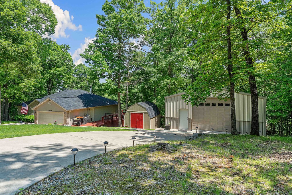 Tucked away on a private road is a 2,780 sqft home that checks all the boxes- 4 bedrooms, 3 baths, a community 12x28 boat slip, large shop and a seasonal lake view for complete lake living! Located on 1.64 acres, the property also features a wood-burning fireplace that can warm the entire home in case the power ever goes out! The eat-in kitchen features granite countertops, stainless steel appliances, freshly stripped & re-stained cabinets, & new hardware. The spacious primary suite includes a luxurious bathroom with a large walk-in shower & walk-in closet. Downstairs, you'll find a fully finished basement with a 2nd living area, bedroom & a bonus room with a wet bar, ideal for entertaining. Step outside to enjoy two expansive decks—1 upstairs & 1 downstairs. The downstairs deck includes a hot tub/firepit. 30x35 workshop with 12-ft garage door & built-in workbench provides excellent space for hobbies. 12x16 shed adds even more storage. Both house & shed -new roofs-2023. Added permanent lights on exterior feature.
