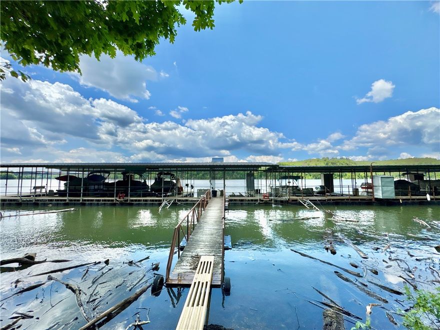 Tucked away on a private road is a 2,780 sqft home that checks all the boxes- 4 bedrooms, 3 baths, a community 12x28 boat slip, large shop and a seasonal lake view for complete lake living! Located on 1.64 acres, the property also features a wood-burning fireplace that can warm the entire home in case the power ever goes out! The eat-in kitchen features granite countertops, stainless steel appliances, freshly stripped & re-stained cabinets, & new hardware. The spacious primary suite includes a luxurious bathroom with a large walk-in shower & walk-in closet. Downstairs, you'll find a fully finished basement with a 2nd living area, bedroom & a bonus room with a wet bar, ideal for entertaining. Step outside to enjoy two expansive decks—1 upstairs & 1 downstairs. The downstairs deck includes a hot tub/firepit. 30x35 workshop with 12-ft garage door & built-in workbench provides excellent space for hobbies. 12x16 shed adds even more storage. Both house & shed -new roofs-2023. Added permanent lights on exterior feature.