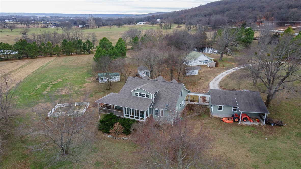 First time to market is this 33 acre family homestead farm located minutes from public land and Lake Wedington. The rolling land is mostly pasture with some timber as well and features a beautiful 3 bed/2.5 bath farmhouse, 2 bed guest house, wet weather creek and 2 ponds. The 2531 sqft home has wood floors throughout the main level. The kitchen has 2 rows of cabinets, 2 sinks, quartz counters and stainless appliances. The living room has an 18' ceiling with transom windows allowing ample natural lighting. The main floor also boasts a formal dining room, eat in kitchen, den, laundry and a huge primary suite. On the 2nd level you will find 2 more large bedrooms and ample storage. The garage, connected by a breezeway, fits 2 cars comfortably, 2 storage rooms and a stall for the tractor. The 2-bed guest house is perfect for the in-laws, teenager or as an rental property. The milk barn is converted to a workshop. Fenced garden plot. 2 ponds stocked with fish. Public water. OzarksGo Internet. Corner parcel.