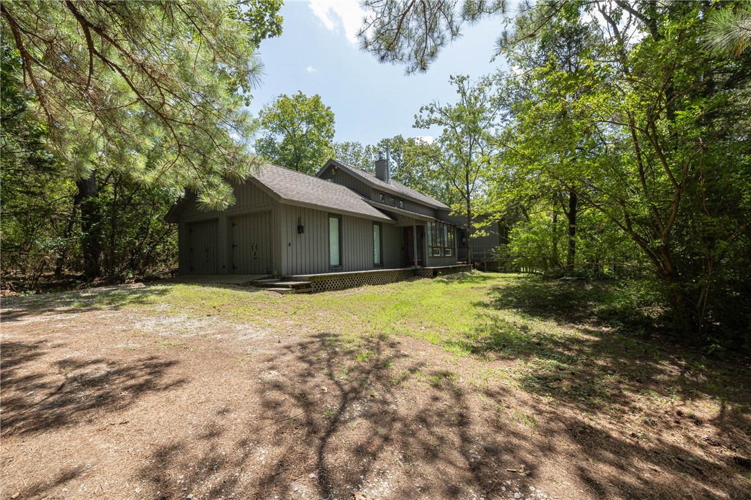 14 mins to Beaver Lake's War Eagle Marina. Seller offering to provide Buyer with $15,000 in concessions to be applied toward closing costs, prepaids, and/or other allowable expenses, with offer and acceptance. Nestled among mature pine trees, this one-of-a-kind 3-bedroom, 2-bath home offers the perfect blend of privacy & convenience. Tucked away on 8 beautifully wooded acres, you’ll feel fully secluded while still being just minutes from shopping, dining, & everyday essentials. Tons of potential in this unique property. Step inside to find two cozy fireplaces and large windows that showcase stunning views of the surrounding property. Home offers abundant storage for hobbies, guests, or a home office.
The attached two-car garage includes a built-in workspace, & the detached two-car garage/shop features a loft w/ a convenient pulley system for easy hauling to the second level—perfect for projects or additional storage. This unique property is ready to welcome its next owner. Call for a private showing today.