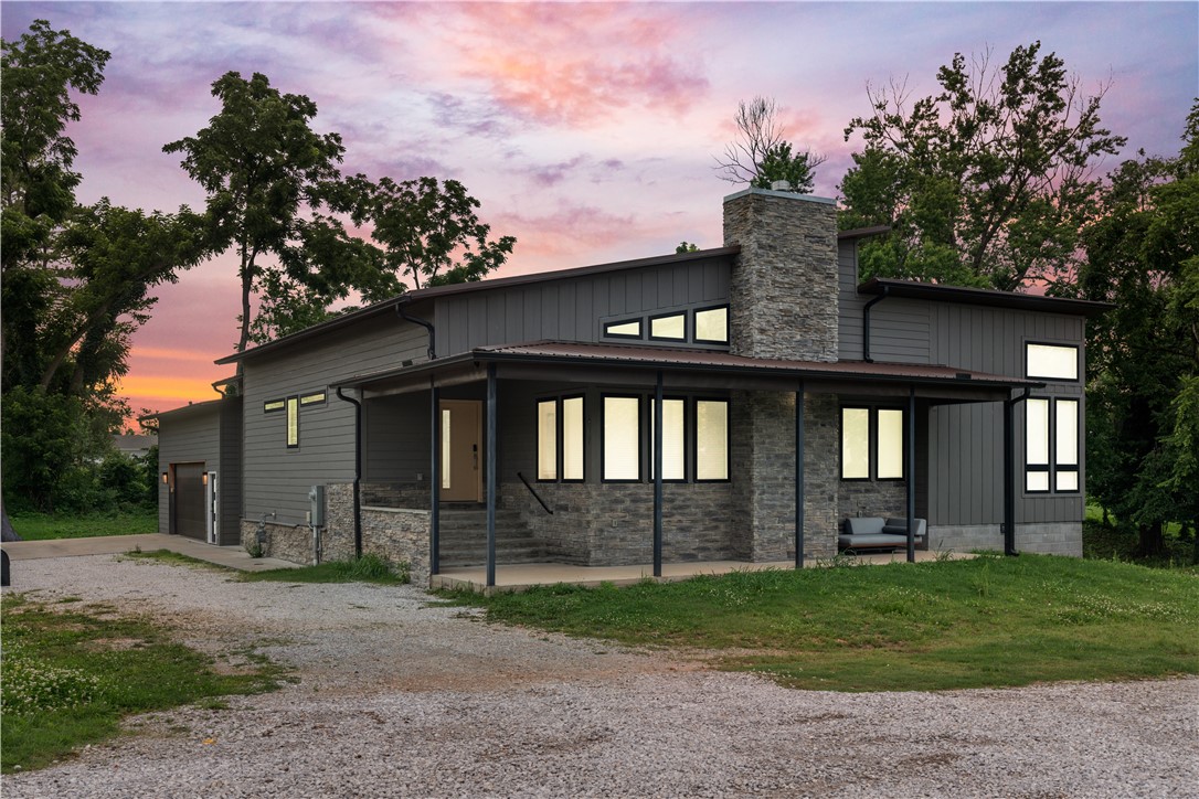 Just blocks from Downtown Bentonville, this 2022 modern home sits on a 0.28-acre lot with clean lines, stone accents, and a covered front porch. Inside, enjoy floor-to-ceiling windows, soaring ceilings, and a fireplace anchoring the open split-floor plan. The chef’s kitchen features a large island, granite counters, ample cabinetry, and a full second kitchen on the lower level. French doors open to a covered patio with TV hookup and fans—perfect for entertaining. The primary suite offers quartz double vanities, a tiled walk-in shower, and dual walk-in closets. With 5 bedrooms, 3 full baths, and 3,696 SF of living space—including a heated/cooled garage—this property was professionally designed as 3 self-contained units. Ideal for short-term rental or multigenerational living in a high-demand location.