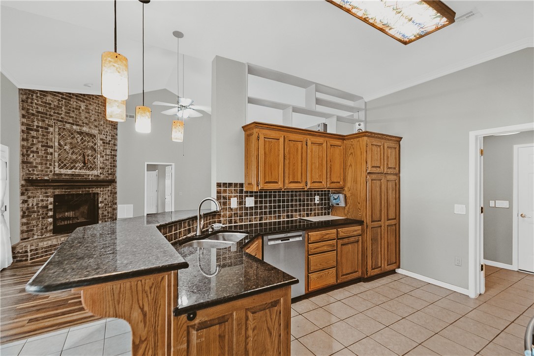 Welcome Home! This beautifully updated 3-bedroom, 2-bath all-brick home is full of charm and modern touches you'll love. Step inside to discover brand new luxury vinyl plank flooring, granite countertops in the kitchen, and a cozy remote-controlled gas fireplace — perfect for relaxing evenings at home. The floor plan offers privacy and comfort, with the spacious primary suite featuring three closets for all your storage needs. Outside, enjoy a large fenced backyard complete with garden beds and mature trees that attract beautiful birds — ideal for anyone who loves a little outdoor living. Just a 5-minute drive to I-49, less than 10 minutes to the Walmart Home Office. Regan Elementary is just a 2-minute drive away, making this an ideal location for families. Come check out this Gem! roof 2019, fridge, washer and dryers are only 2 years old, convey with acceptable offer.