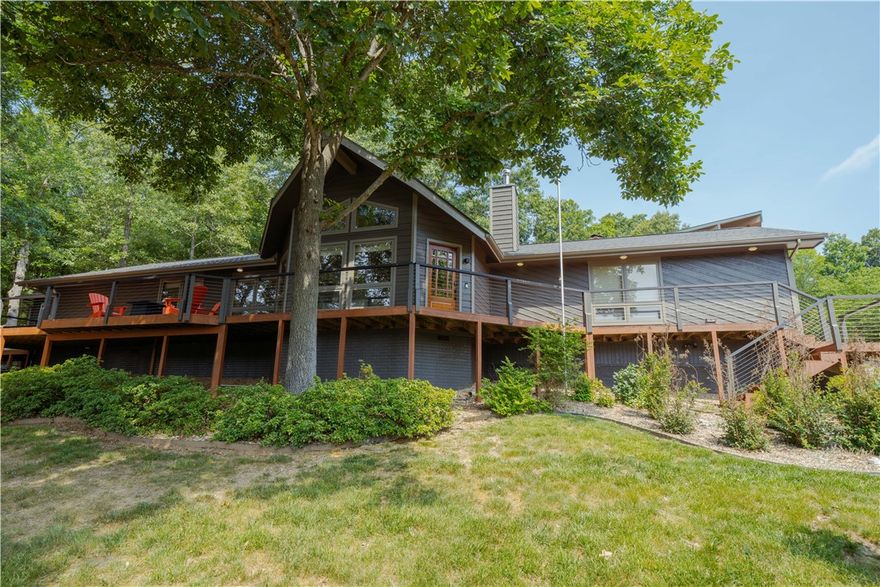 Welcome to a beautiful retreat moments from Lake Windsor offering stunning lake views and a peaceful natural setting. Designed to capture the beauty of its surroundings, the open-concept living area features cathedral ceilings with large windows that fill the space with natural light and frame the scenic landscape. The kitchen and dining area provide a comfortable space for everyday living and entertaining, while the expansive front deck extends the living space outdoors. A fire pit area creates an inviting setting for evenings under the stars. Additional features include a private indoor hot tub, offering a relaxing retreat year-round. Whether used as a primary residence, second home, or investment property, this home combines comfort and character in the highly sought after Mayfair subdivision. The adjacent lot is included to provide extra privacy. Enjoy the tranquility of lake living with convenient access to outdoor recreation such as the Tanyard Creek trails, golf courses, and renowned mountain biking trails.