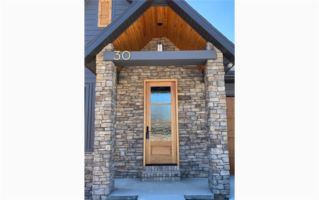 Welcome to this stunning home in Bella Vista’s new Trail Ridge subdivision, offering modern living with exceptional details throughout. The main floor features a beautifully designed kitchen, laundry room, master suite, living room, and a dining room/office. The kitchen boasts rosemary-painted cabinets, quartz countertops, & a full, Frigidaire Professional appliance package, including a refrigerator. The master suite includes heated floors in the master bath for added comfort. With a luxurious master suite and thoughtful details throughout, this home truly feels like a retreat. The finished walk-out basement offers even more room to relax or entertain, with two bedrooms, a full bath, a hobby room (which could be a 4th bedroom) and a rec room that leads directly to the lower-level patio. With stone accents, modern siding, and sleek black Marvin windows, this home exudes charm and sophistication. Enjoy peaceful views of the Tunnel Vision trail, blending natural beauty with modern living.