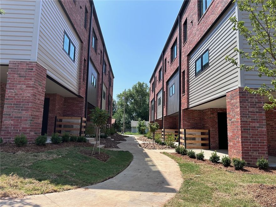 New Construction, SoMa Bentonville, 2 bedroom 2 1/2 bath Townhome 1 block from the new Walmart Campus. Great space with a modern industrial vibe. Water proof wood style flooring throughout. Open concept, with lots of natural light Kitchen includes stainless appliances and solid surface counters. Each bedroom has a private bath and large closet. Covered patio and 1 car garage. Landscape included. Pets negotiable and include additional pet rent and non-refundable deposit.