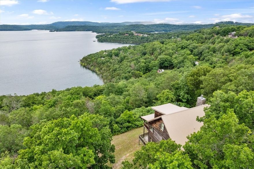This stunning +/- 2,480 SF luxury cabin home offers breathtaking views of Beaver Lake and the perfect
blend of comfort and rustic charm. Nestled just 1.3 miles from the nearest boat ramp and 12 miles from
Eureka Springs, this beautifully designed home features 3 spacious levels and 4 beds/2 baths. The main
floor includes a living room with a fireplace and balcony access overlooking the lake, an eat-in kitchen, and a primary bedroom (with jacuzzi tub) that also opens to the balcony and a full bathroom. Upstairs, a large loft overlooks the living room and can serve as a bedroom. The walk-out basement level features a large family room with deck access, 2 bedrooms-one with deck access-a full bath, and a washer/dryer.
Throughout the home, you'll find vaulted ceilings on the main floor, hardwood floors and carpet flooring. Whether you're relaxing on the deck or the balcony, this lake view cabin is the perfect place to unwind and enjoy the natural beauty of Beaver Lake!