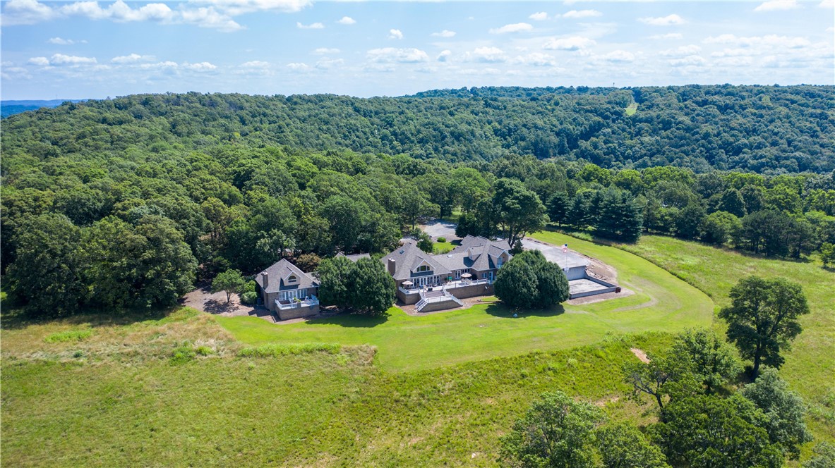 Crescent Meadows Estate is a 32.607 acre estate located on the third highest peak in Carroll County at an elevation of 1634ft. The property has a 180 degree unobstructed view of the Ozark Mountains near Hillspeak Community.
Architect Michael Buono, Fellow American Institute of Architects designed the 6303sf home and was built in 1991 by the late Virgil Van Winkle of Green Forest for the one owner Dr. Charles and Mrs. Beverly Beard.
The estate includes 5 bedrooms, 5 ½ bath, 4 car garage (1230sf) with workshop area, guest suite over garage, two fireplaces, library, floating office or creative space, recreation/game room, multiple offices or music rooms, gym (with sprung floor), numerous closets & storage rooms in attic, basketball court, 2100sf spacious deck along back of house; gas wood stove in guest suite with remote; main laundry room has space for sewing; laundry room in guest suite next to bathroom; walk in pantry.
This estate has so much to offer!
Additional photos, drone & interior video available