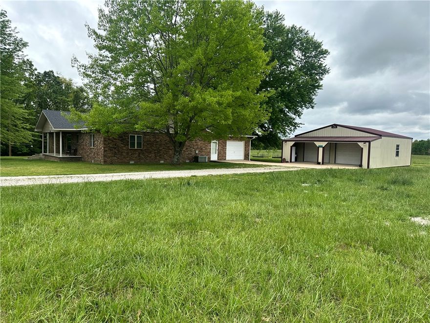 Location location! Easy access to get to Hwy 59, Hwy 102, or AR-12. Enjoy 4.97 acres already set up for a homestead! Brick home with covered front and back porch. One car garage attached to the home as well as 2 car garage door workshop has room for parking, hobbies, storage, etc. Home features a beautiful kitchen with timeless wood cabinetry, granite counter tops, and a bar long enough for 4 stools. All the rooms in this home are a fantastic size including the living room. There is plenty of space for the whole family on movie nights. Extend entertainment space to the back porch. Stay warm all winter long with a modern pellet stove. Primary bedroom has a double vanity, whirlpool tub, and walk in shower with a bench. Fruit trees, raised beds, and even a chicken coop already set up. You will have fun on the trails made through the wooded part of the property.  Shop is 30x30 with 8ft extended front for extra coverage. New roof in 2022. You won't want to miss out on seeing this property and making it your new home!