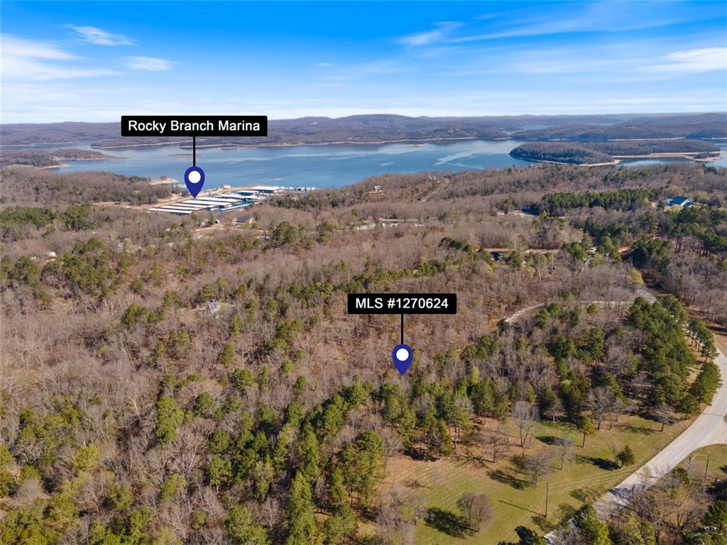 Unlock your dream retreat! This 1.66-acre gem, spread across 2 lots, offers a picturesque blend of sloping terrain and lush woodlands, providing the perfect canvas for your dream cabin or vacation home. Nestled near the esteemed Rocky Branch Marina & Campground on captivating Beaver Lake, relish in the opportunity to create your ideal lakeside escape. Enjoy easy access to hiking & biking trails, the renowned Hobbs State Park, and the vibrant energy of Downtown Rogers, all while basking in the serenity of this secluded oasis just outside city limits. Don't miss your chance to experience the beauty of Northwest Arkansas in your own piece of paradise!