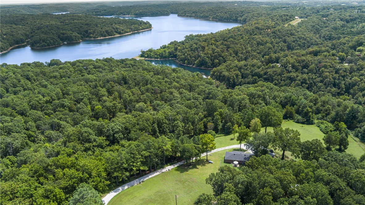 Set on just over 21 acres, this updated home blends modern comfort with timeless charm while enjoying privacy & stunning seasonal lake viewsāpartial in summer, full vistas in fall & winter. The homes updated interior features 2904 sq ft with 3 bedrooms, 2 bathrooms, solid hickory flooring, fresh paint, new doors & trim, LED lighting & fully remodeled basement with bonus room & recreational flex space. Living room centers around a gas log fireplace, while the eat-in kitchen includes stainless steel appliances & bar for casual dining. Thoughtful upgrades abound: new tankless hot water heater, new roof on home & garage, whole-home generator w/500-gallon propane tank, Tesla charger, 30 amp RV service, expanded driveway, added culverts & fencing, new landscaping & sod, cedar-wrapped porch columns & custom swing. Outdoor, a firepit, trimmed canopy trees, & open acreage create a park-like retreat. Just minutes to town yet completely private, this property offers a rare combination of beauty, convenience & lake lifestyle.