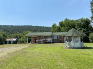 Take a look at this brick 2 bedroom 2 bath home on 9 acres. This home offers a carport with storage and laundry area. Fenced with pasture and a pond for horses, cattle or goats. Storage building with concrete floor and electric. Central heat and air is about 2 years old, average electric bill is $97 a month, and kitchen was remodeled and offers newer appliances. The room that is currently used as the dining area was originally another bedroom, and could be converted back into one. National Forest is just behind the house.