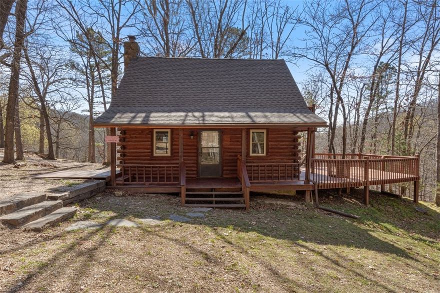This peaceful cabin is nestled near the quiet shores of one of Red Bud Valley's two private ponds. It has an idyllic outdoor space, with 800 square feet of deck including a balcony off of the loft bedroom and fire pit in the well-maintained yard. The newly roofed cabin has a cozy wood burning fire place in the main room, washer/dryer hook-ups downstairs, and a half bath in the loft bedroom. The open floor plan and loft create an airy feel to this cabin that can be used as a primary residence or a nightly rental. Red Bud Valley's private community offers walking trails, gardens, a playground, and a common use clubhouse. Your new cabin is conveniently less than 10 minutes to Eureka Springs and close to Kings River Trigger Gap Outfitters, so you can enjoy the best of both worlds!