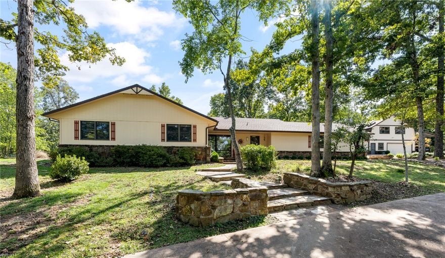 Less than mile from Coler Mountain Bike Preserve. The acres have open space, lots of trees, firepits, decks, patios; property feels like a retreat; peaceful setting. From indoors, nature is appreciated because of large windows & skylights. Main living space is large/open; allows versatility to furnish for a preferred lifestyle; whether to use the space for large sofas & chairs, dining areas, game tables, piano, or other furnishings. There is a lot of minimalist style cabinetry throughout the home with clean lines and a focus on simplicity & functionality that creates a calm and uncluttered environment. A safe room (565 sq.ft.) is in the lower level. Home also has a sauna. The location adds much value to this property. It is a rural setting where homes have large lots, yet just a few minutes to Bentonville Square, Museums, Walmart Home Office, and many trails. There is a 1500 sq.ft. heated/cooled 2-level shop with car lift & other equipment. There's a generator for the full house & shop with 1000 gallon propane tank
