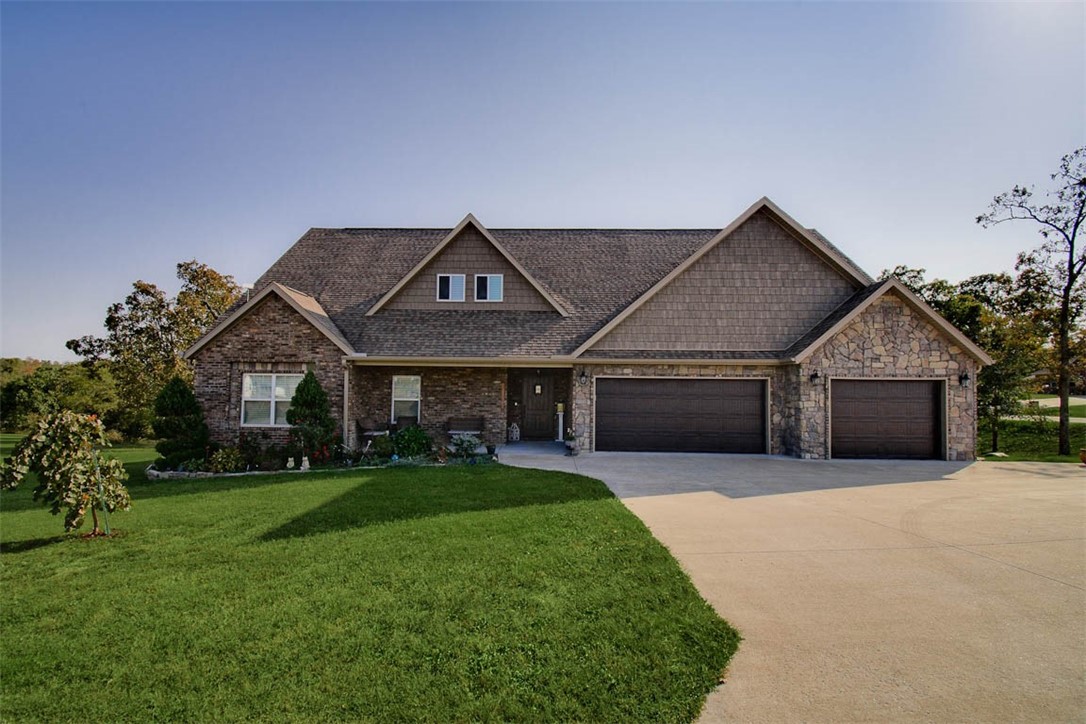 Welcome to charming country living on 1 acre with the convenience of city amenities! This custom-built home in Moonlight Valley Subdivision blends high-end finishes, thoughtful design, ample storage, and custom touches throughout! The main level features wood-look tile flooring throughout & an open-concept design featuring a gorgeous chef's kitchen and 3 generously sized bedrooms! The spacious, sunlit primary suite includes a large walk-in closet and a spa-inspired bathroom featuring an oversized shower! Upstairs, you'll find an additional room/flex space with a bathroom, a versatile bonus area, & a dedicated office space, perfect for work or study. Wait until you see the upstairs second kitchen, cleverly concealed behind built-in cabinetry boasting gorgeous finishes! Step outside and enjoy the covered back deck with a stone-surround fireplace that overlooks a peaceful wooded area. This home has plenty of space for everyone! Located minutes to the bypass and just a short commute to the Walmart Home Office!