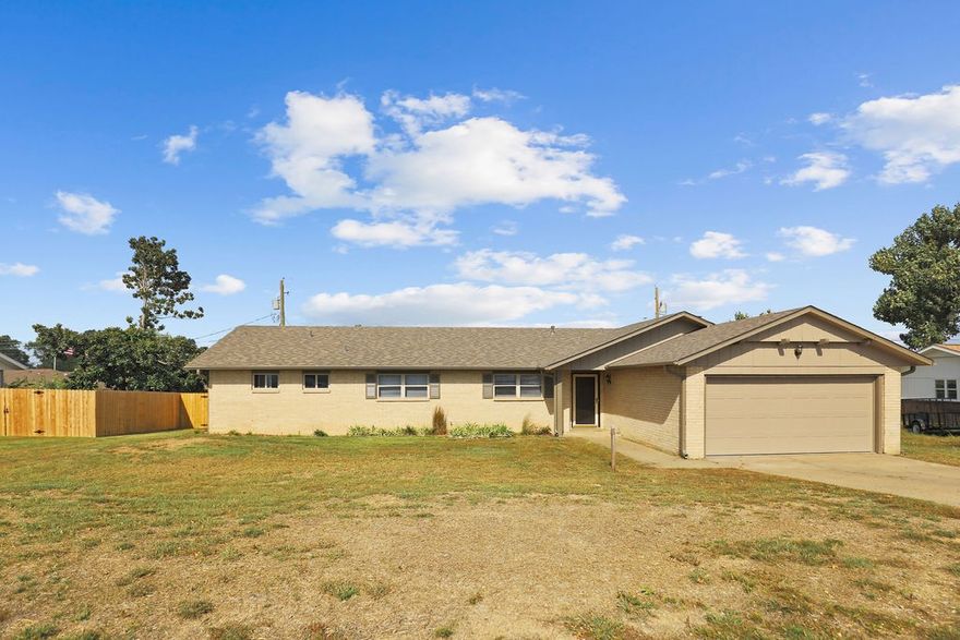 Welcome to this completely renovated brick home in a prime Rogers location near the Amp and downtown. This move-in ready property has been thoughtfully updated from top to bottom with a brand new roof, double pane vinyl windows, fresh guttering, and professional landscaping. Inside, you'll find beautiful  wood floors, new carpet, and tile throughout. The living area features a cozy fireplace with gas starter, complemented by modern LED light fixtures and new blinds. The kitchen offers granite countertops, a dishwasher, double oven, and electric cooktop, plus a refrigerator, washer, and dryer. All 3 bedrooms have been freshly painted, and the bathrooms shine with new tub-shower combos, toilets, mirrors, and fixtures. The primary bedroom provides convenient access to updated bathroom with linen storage. Additional highlights include a new garage door with opener, and new water heater. Step outside to enjoy the covered patio with new awning and epoxy flooring, all enclosed by a brand new six-foot wood privacy fence.